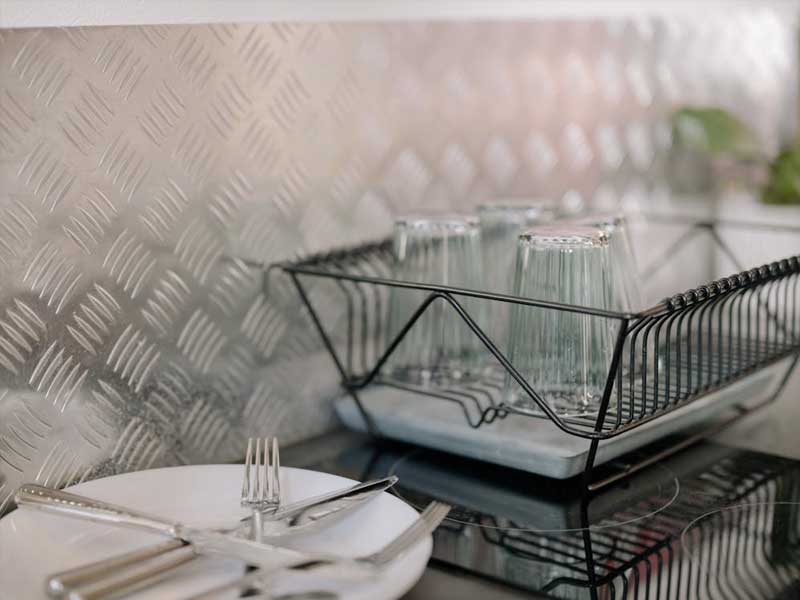 Sparkling clean glasses and neatly arranged dishes in a bright, tidy kitchen, showcasing Lenuma’s premium residential cleaning standards.